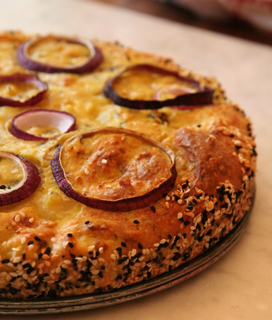 Blomkoolkoek met sy mooi kragie van sesamsade en die rooi uieringe as versiering. 