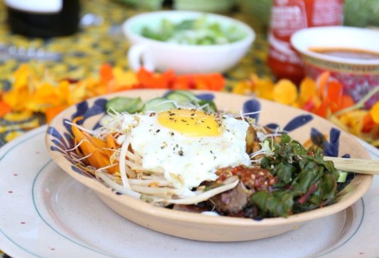 Bibimbap bestaan uit rys wat omring word met bykosse, piekels, rooisous en 'n gebakte eier.